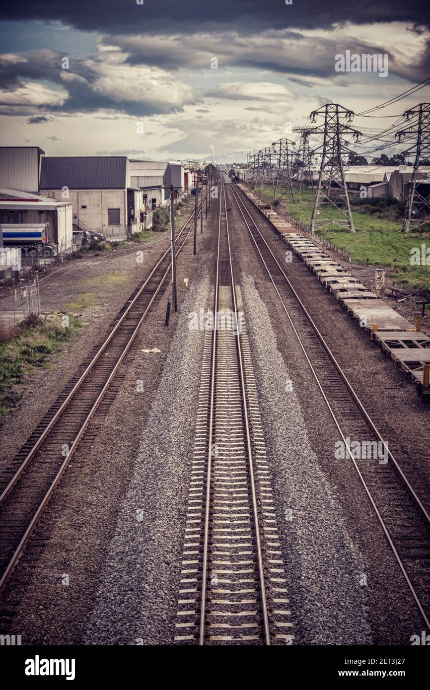 Lignes de chemin de fer et lignes de distribution d'énergie haute tension sous un ciel spectaculaire; filtre de type Instagram. Banque D'Images