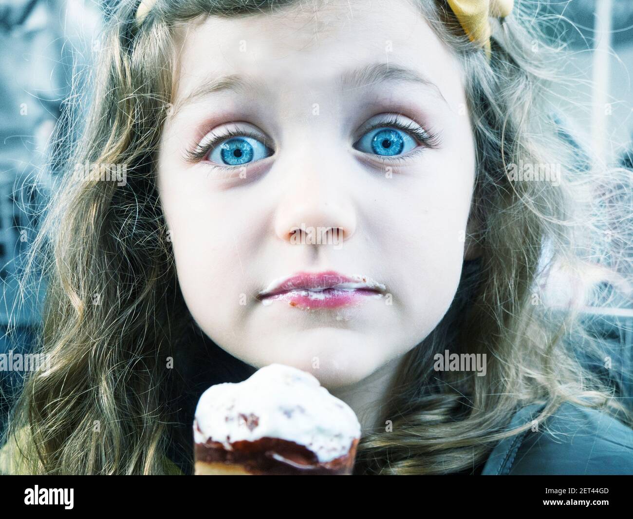 Portrait d'une fille surprise avec piercing yeux bleus manger crème glacée Banque D'Images