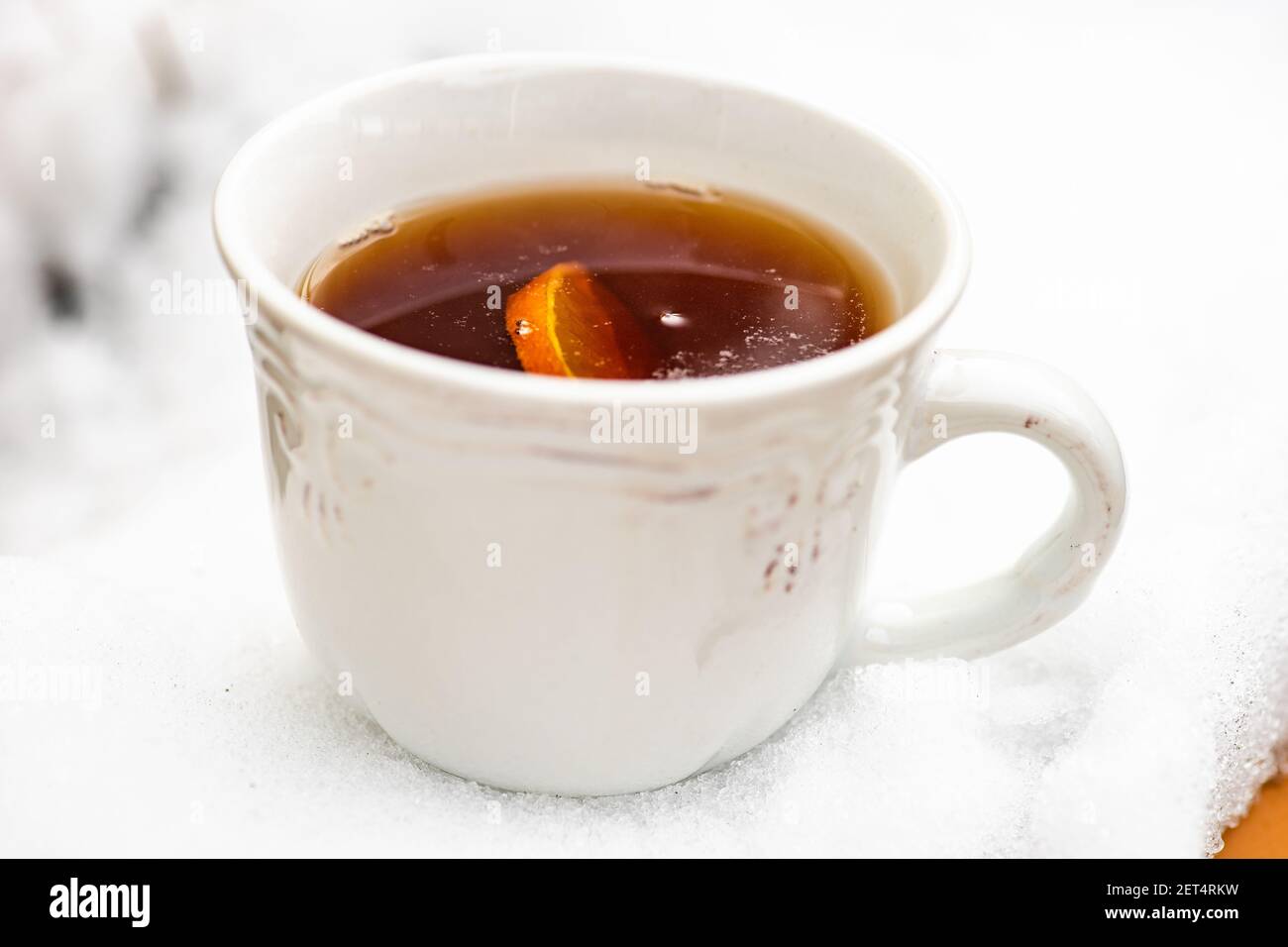 Tasse de thé noir avec une tranche de citron une table couverte de neige à l'extérieur Banque D'Images