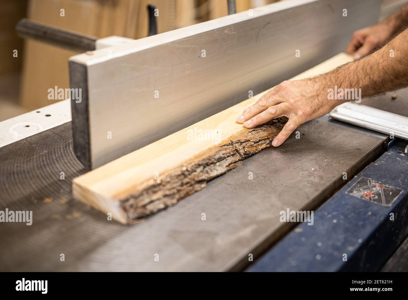 Un homme assis sur une planche à découper en bois Banque D'Images