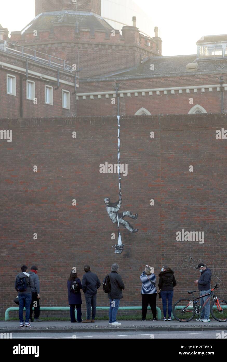 Les gens prennent des photos d'une œuvre qui a paru sur le mur de l'ancienne prison de Reading, Berkshire. Date de la photo : lundi 1er mars 2121. Banque D'Images