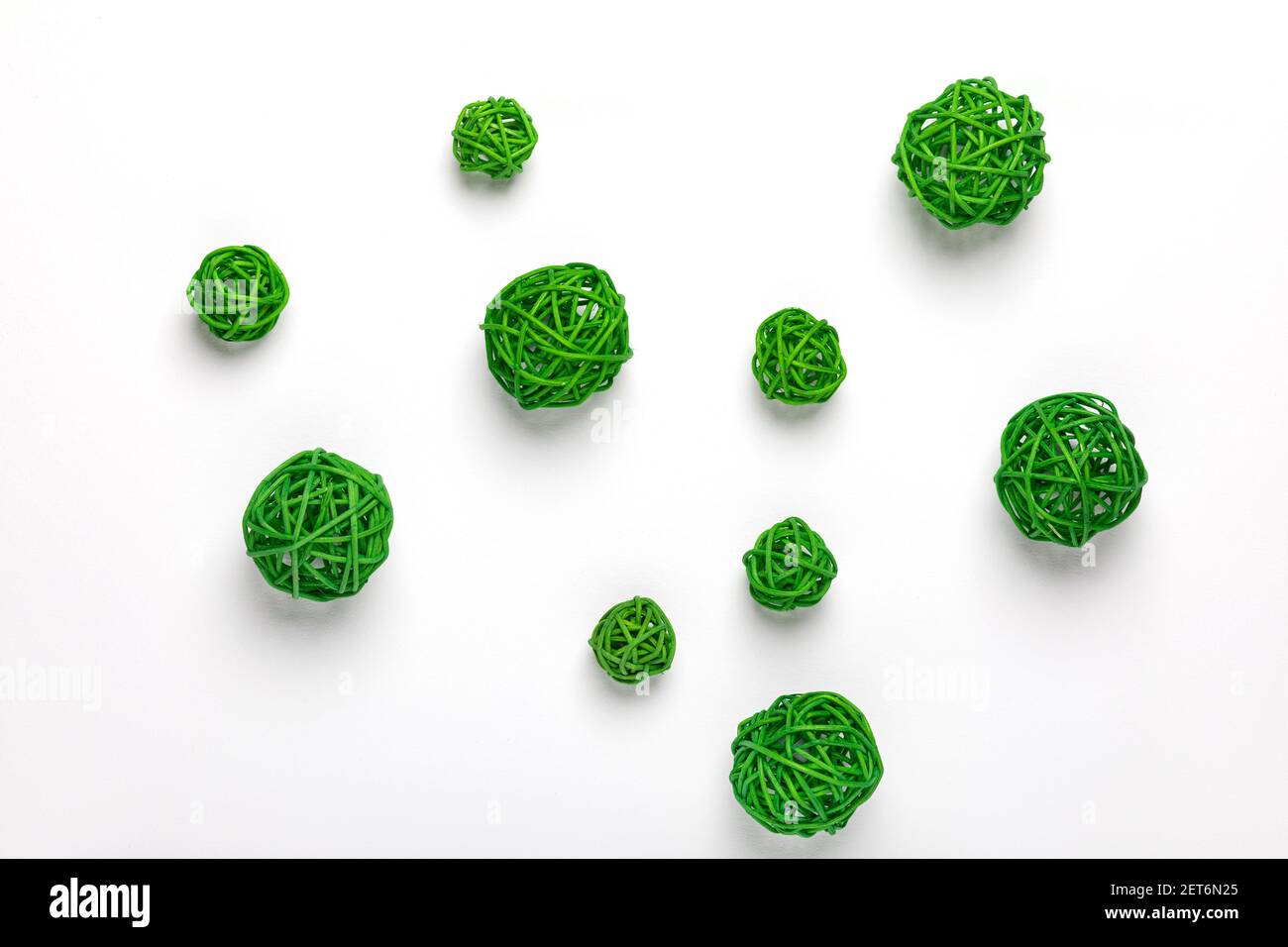 Boule décorative verte en rotin, canne espagnole, tiges de calamus. Forme de cercle ou de balle en osier chaotique. Un groupe isolé d'objets ensemble sur fond blanc Banque D'Images