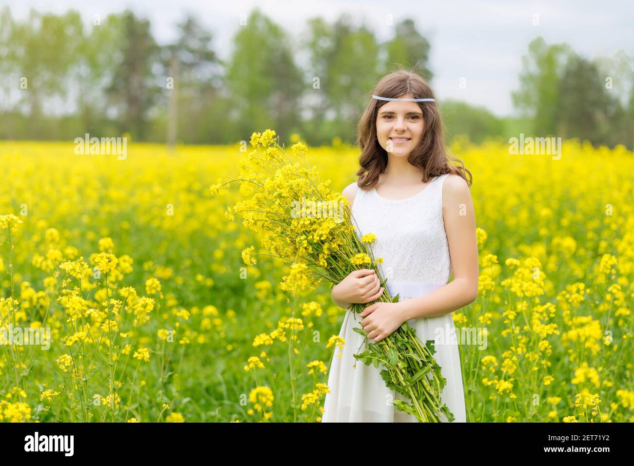 Un enfant dans un champ fleuri avec des fleurs jaunes. Banque D'Images