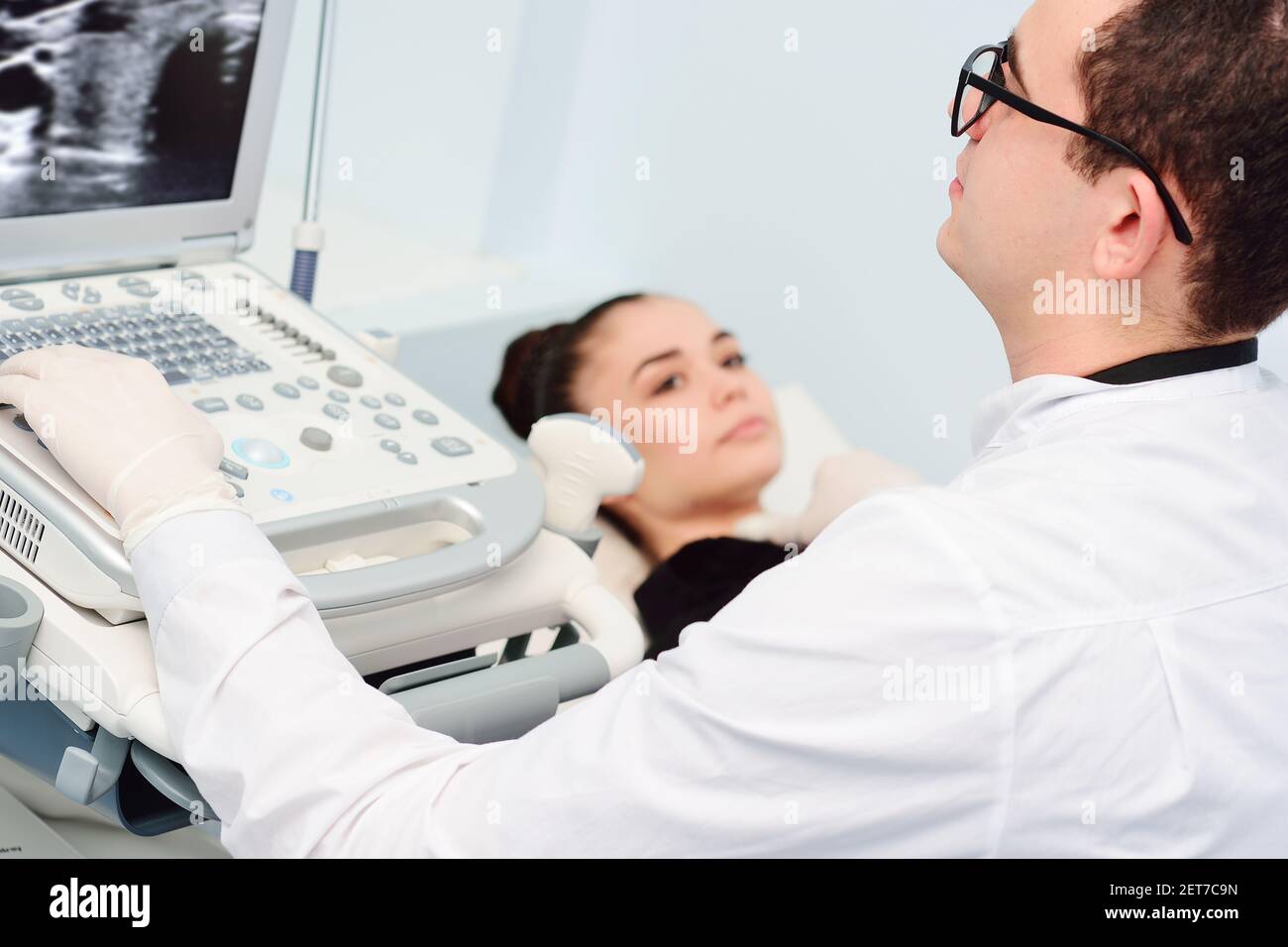 le médecin effectue un examen échographique de la glande thyroïde d'une jeune, jolie femme dans une clinique moderne. Prévention du cancer de la thyroïde. Banque D'Images