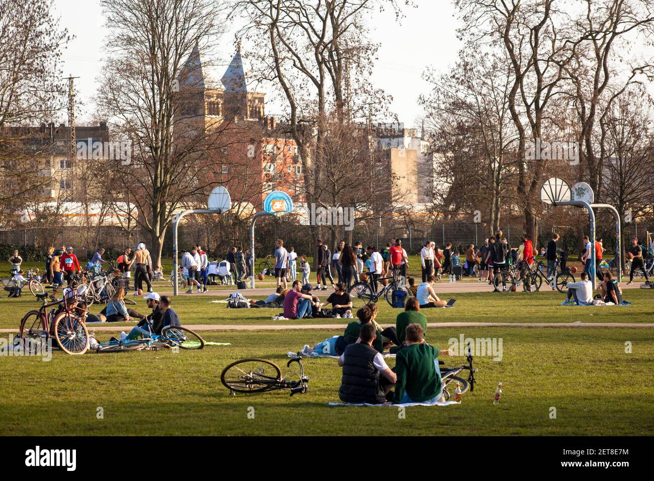 Les gens profitent d'une journée exceptionnellement chaude le 24 février. 2021 dans le parc Innerer Gruenguertel, église Saint-Michel sur Bruesseler Platz, Cologne, GE Banque D'Images