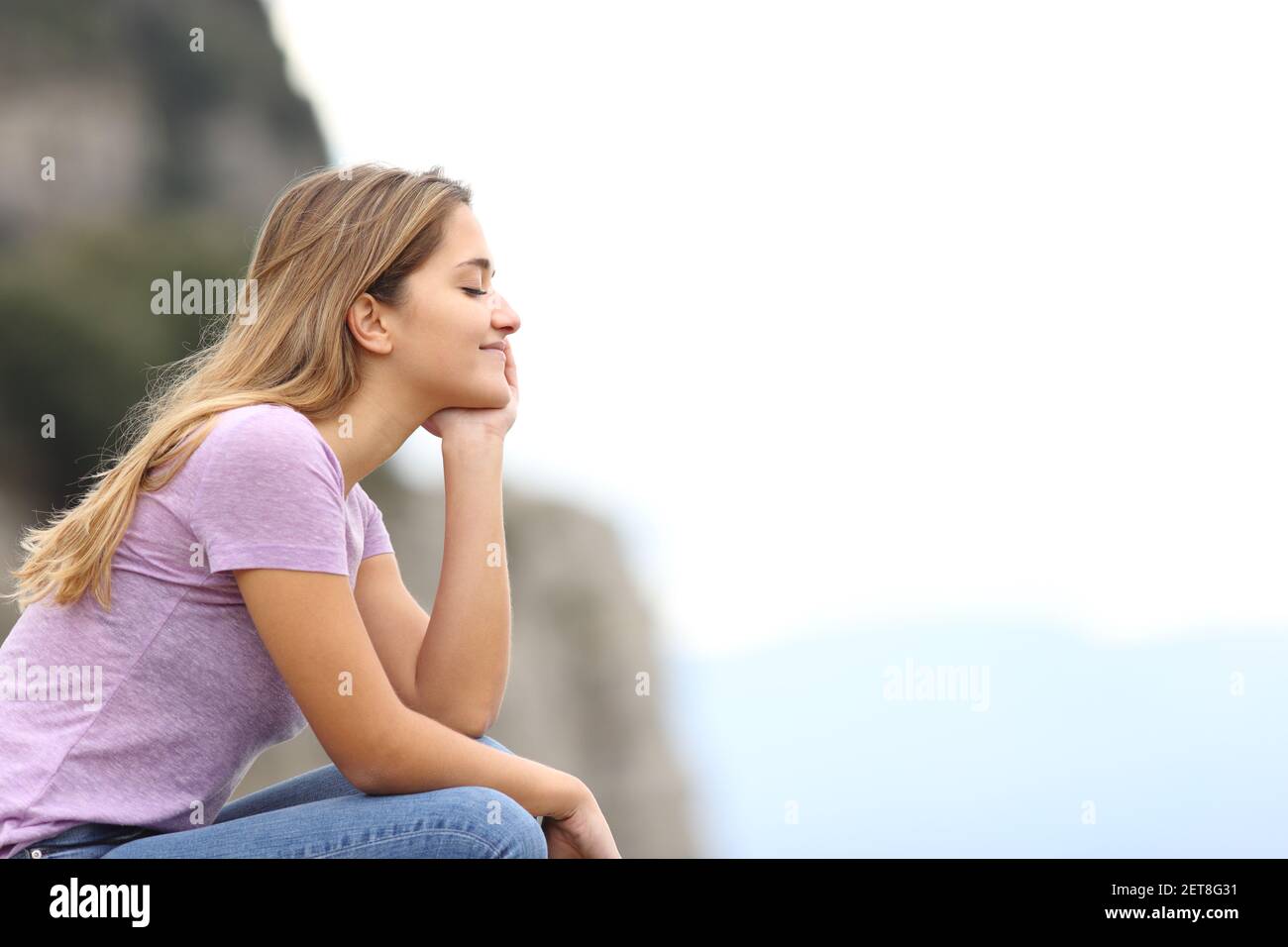 Vue latérale d'une femme heureuse se relaxant méditant la montagne Banque D'Images