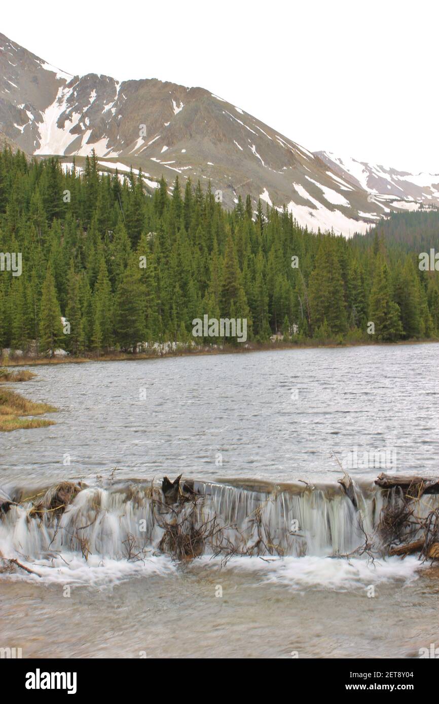 Un lac de montagne froide se cascade sur un barrage de castor Banque D'Images