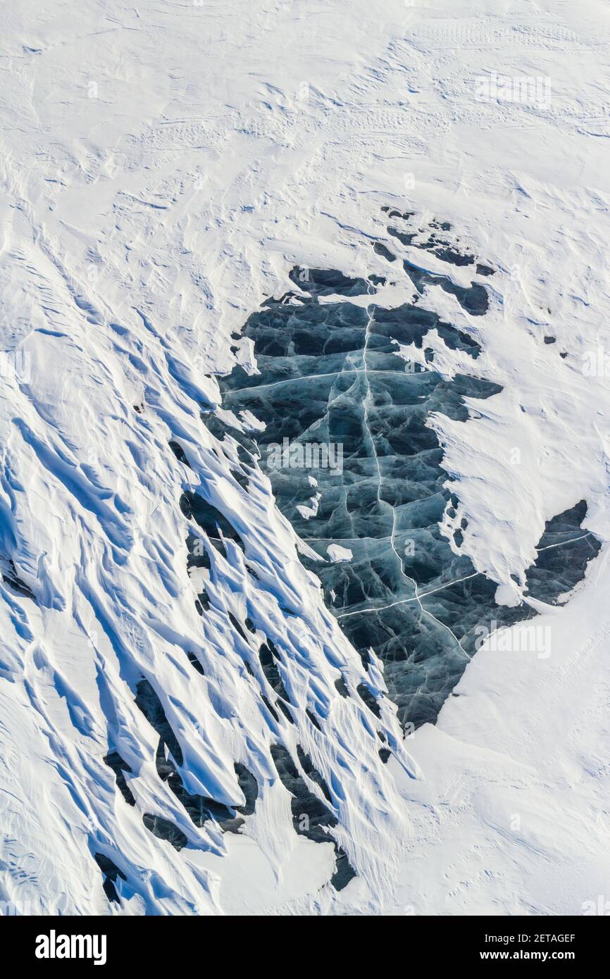 Vue aérienne abstraite de la neige et des fissures de glace gelée dans le lac, dans l'Arctique canadien. Banque D'Images