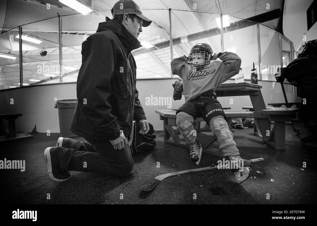 Ryan Suter aide son fils Brooks, 6 ans, à enlever son équipement après son entraînement au Minnesota Made Hockey à Edina, Minn. (Photo par Carlos Gonzalez/Minneapolis Star Tribune/TNS) *** Veuillez utiliser le crédit du champ de crédit *** Banque D'Images