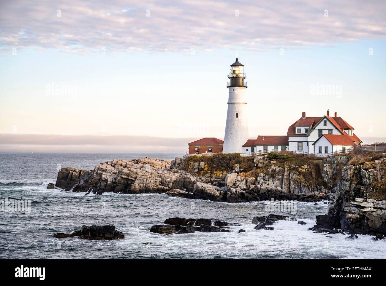 Aménagement paysager de la côte silencieuse de l'océan Atlantique Nord-est avec horizon à marée basse avec des rochers lavés par les vagues et Véritable phare opérationnel à l'to Banque D'Images