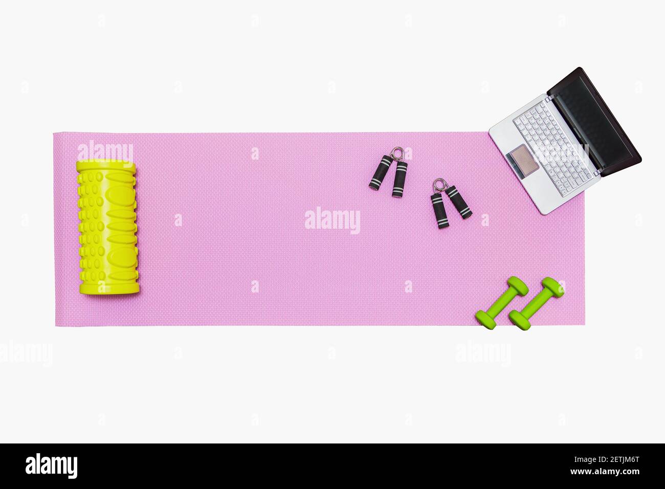 Tapis de fitness, haltères, extenseur et ordinateur portable pour les entraînements en ligne à la maison. Concept d'éducation en ligne en relation avec la pandémie. Isolé sur blanc Banque D'Images
