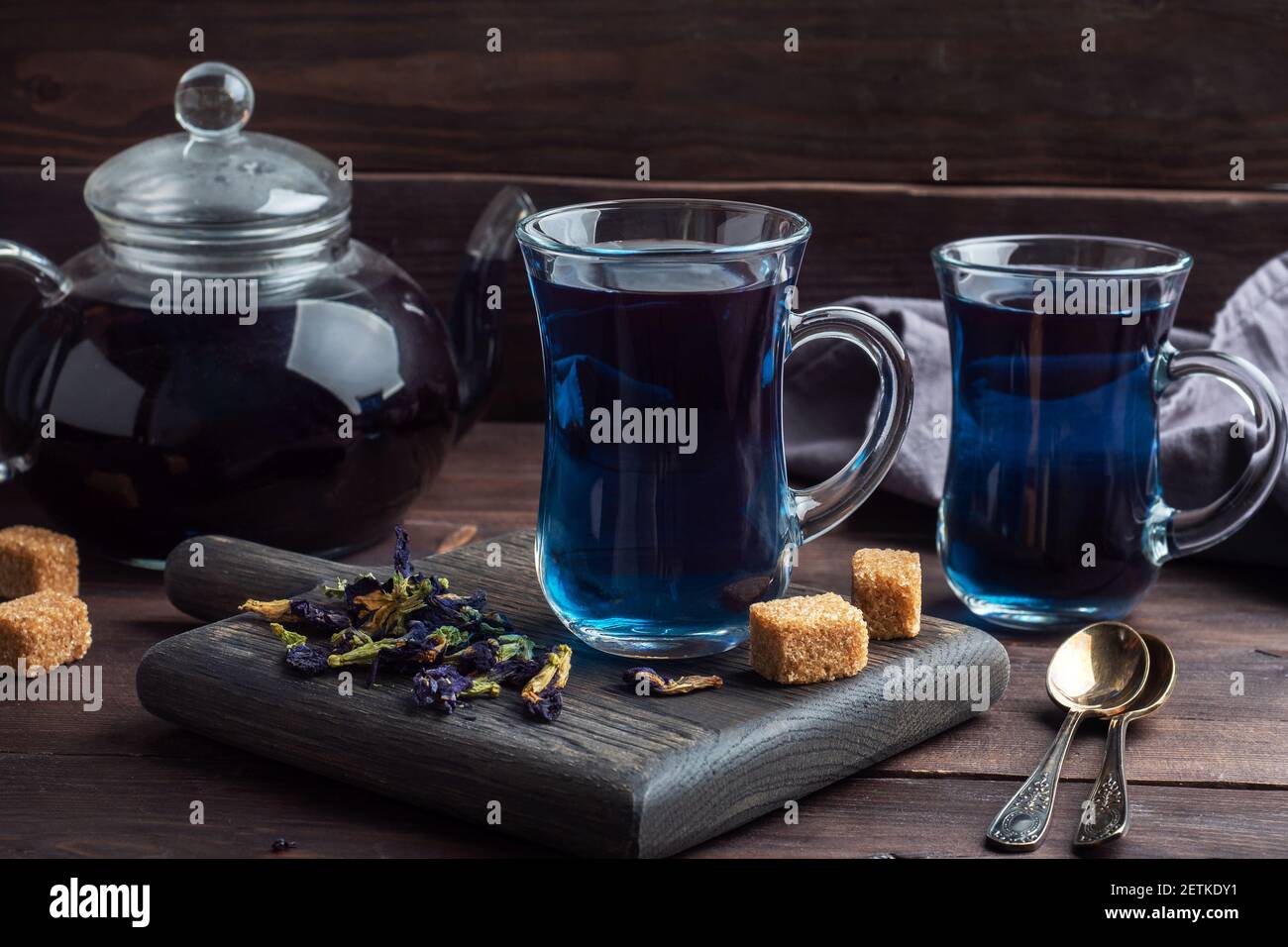 Thé thaï bleu anchan de bourgeons klitoria Ternate dans une tasse de verre, fond sombre Banque D'Images Thé thaï bleu anchan de bourgeons klitoria Ternate dans une tasse de verre, fond sombre Banque D'Images