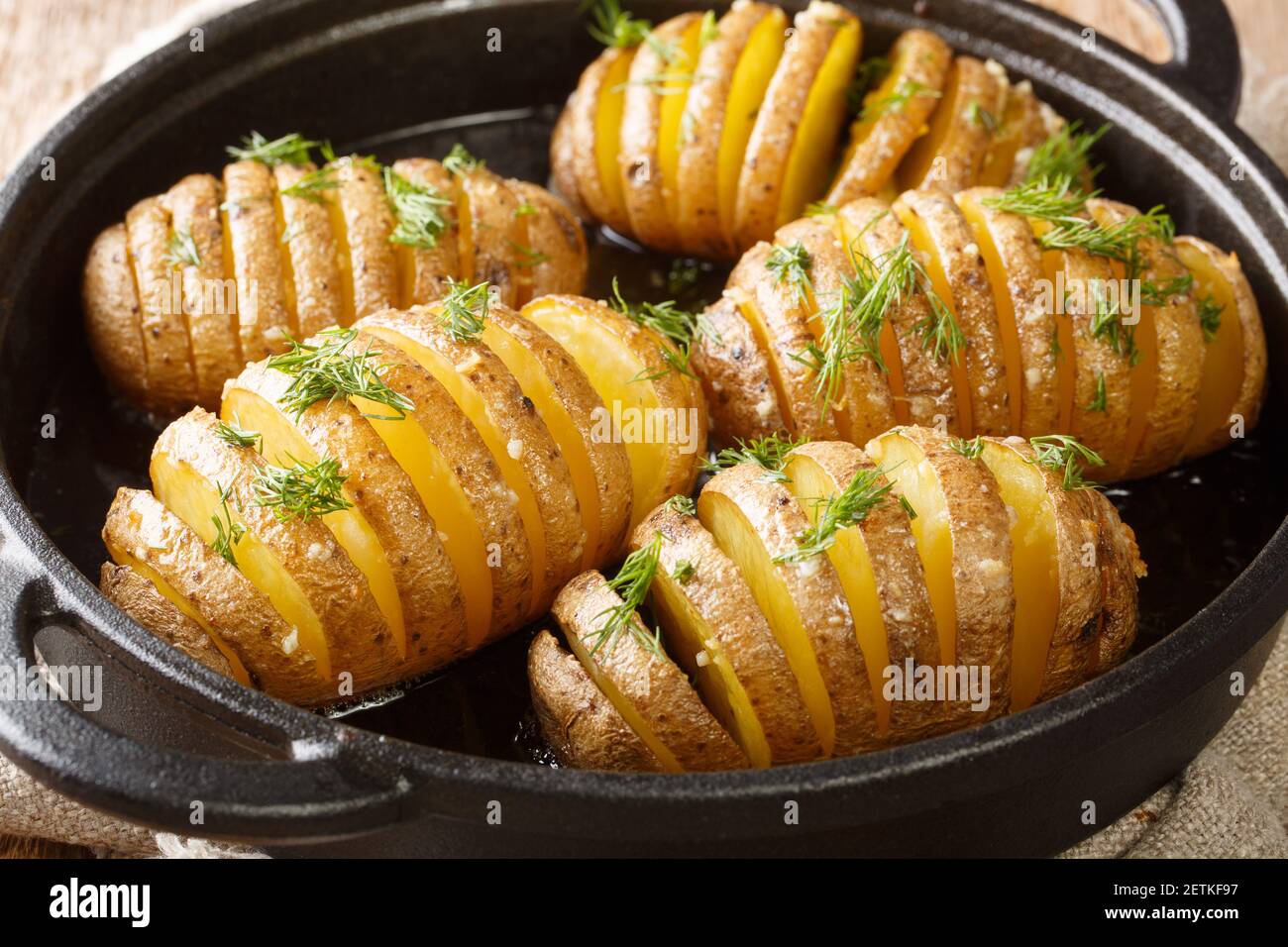 Les pommes de terre Hasselback sont un style de pommes de terre cuites au four qui a été créé dans une taverne en Suède appelée Hasselbacken gros plan dans une casserole sur la table. Horiz Banque D'Images