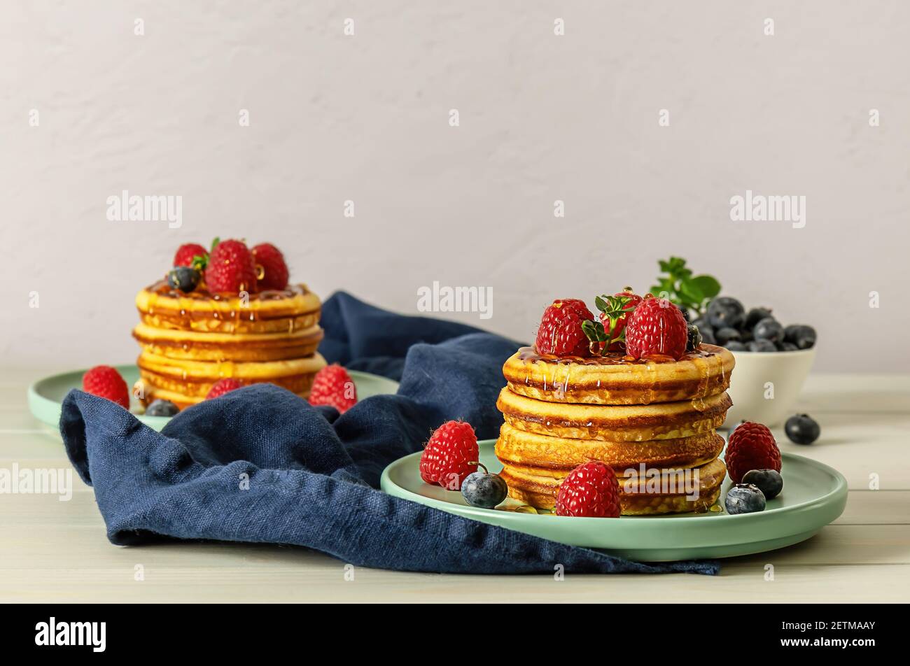 Crêpes américaines savoureuses aux framboises, aux bleuets et au miel. Banque D'Images