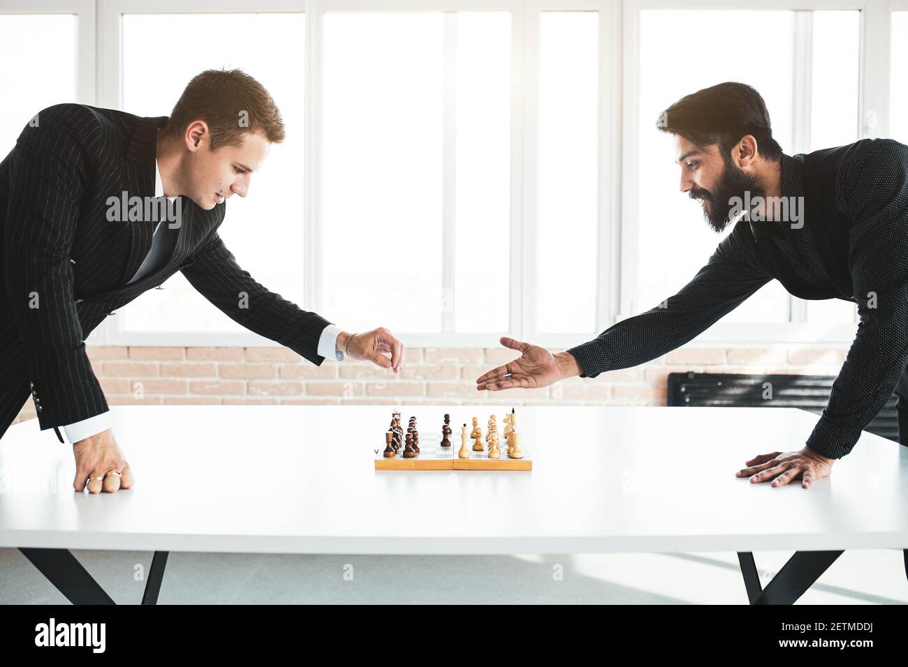deux hommes d'affaires, rivaux, jouent aux échecs. Stratégie et rivalité. Banque D'Images