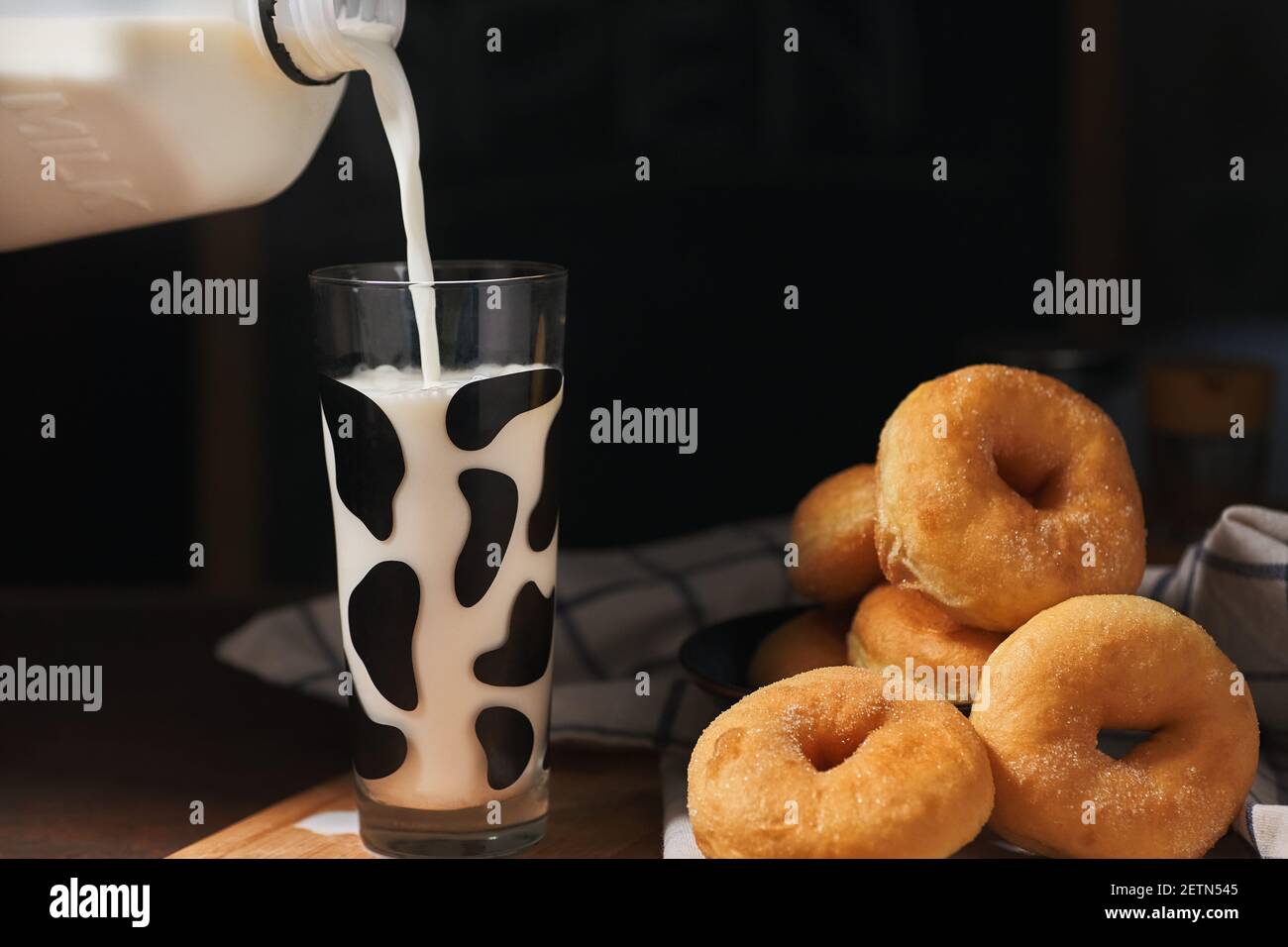 Verser le lait à manger avec des beignets de sucre Banque D'Images