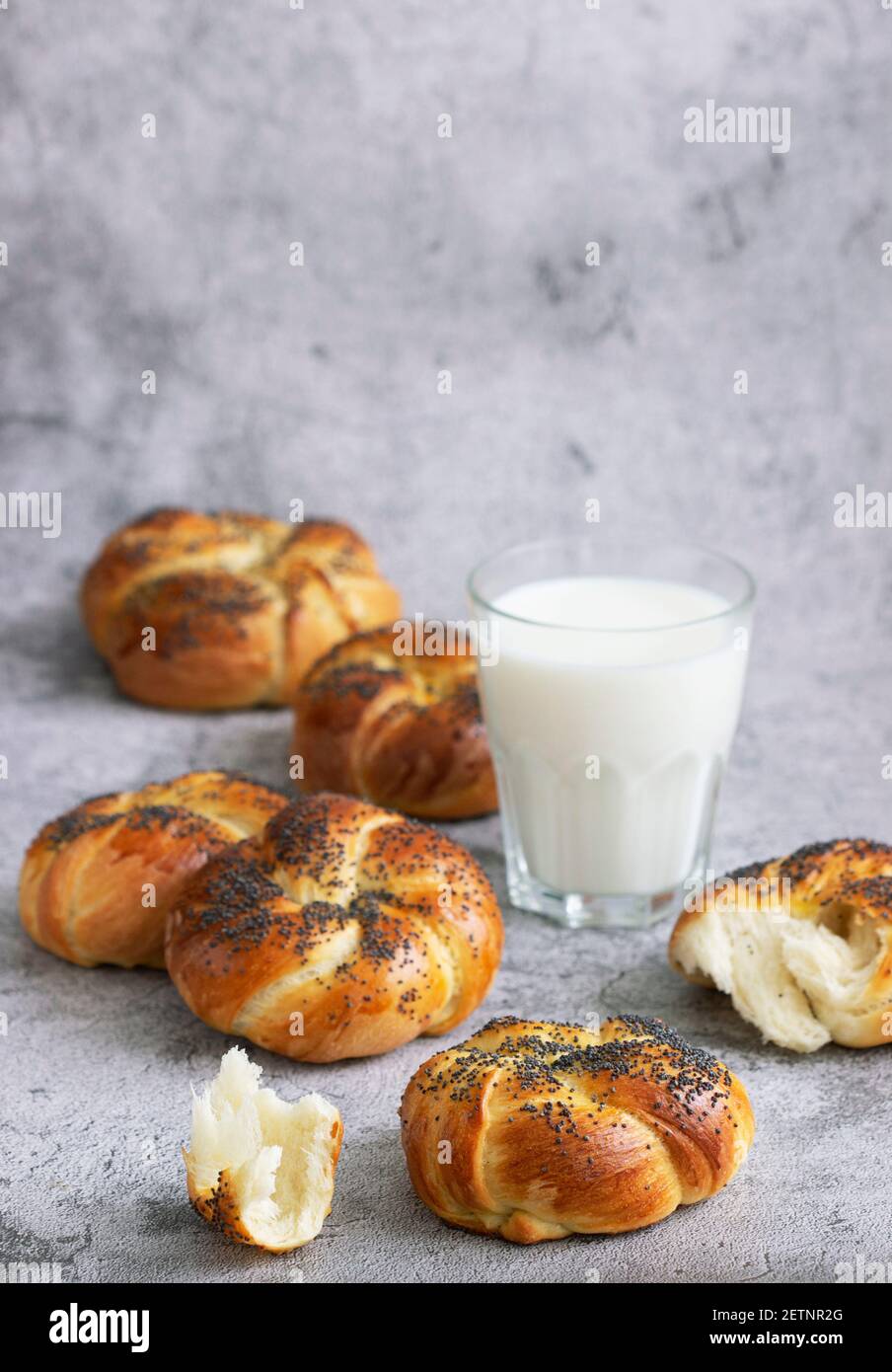 Petits pains sucrés aux graines de pavot servis avec du lait. Banque D'Images