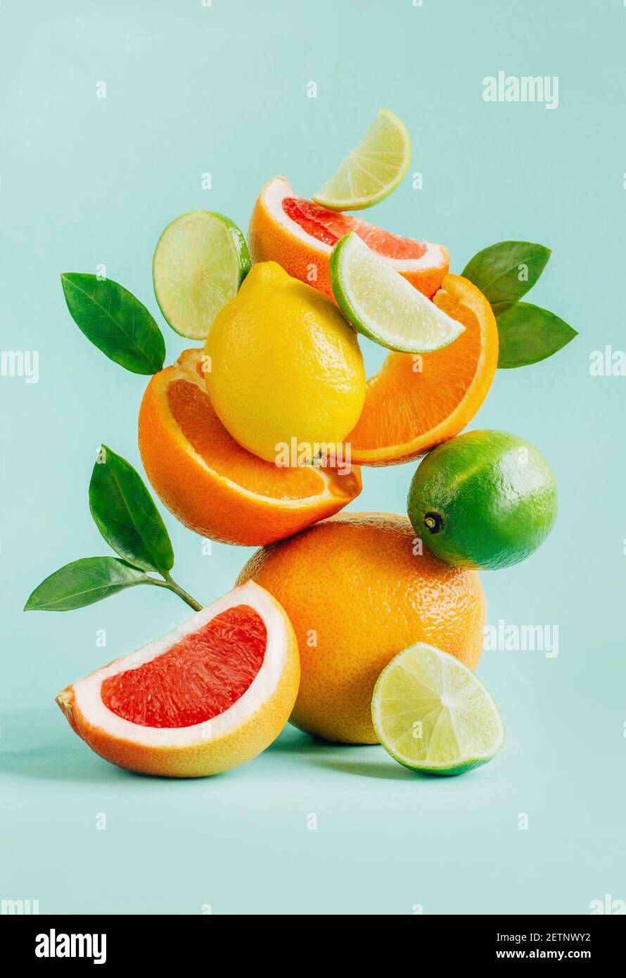 pyramide de pamplemousse, citron, orange et citron vert, ornée de feuilles sur fond bleu Banque D'Images