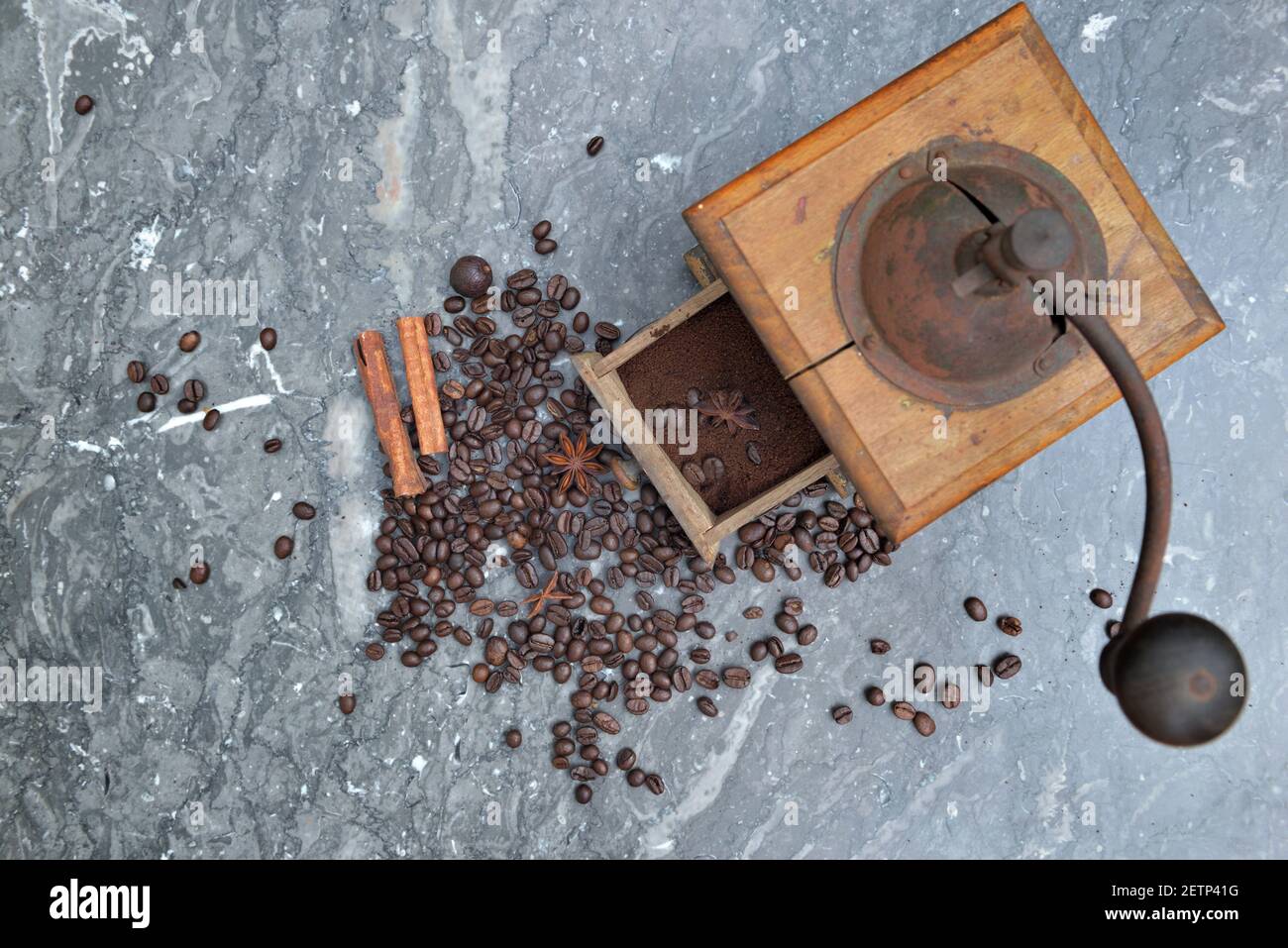 vue de dessus sur l'ancien moulin à café plein de café et haricots avec épices sur fond de marbre gris Banque D'Images