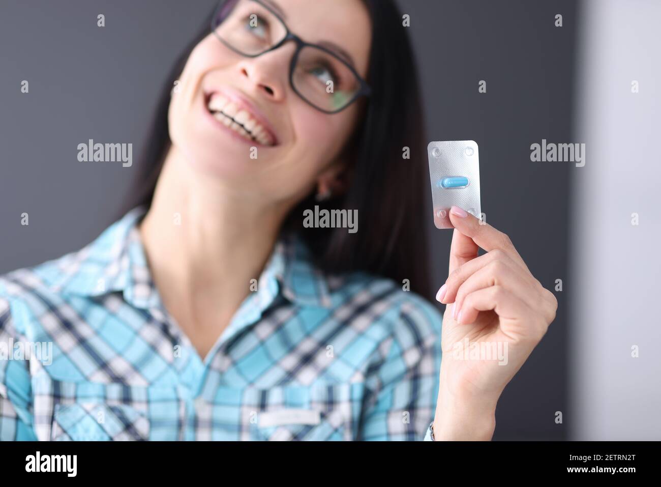 Femme contentée tenant un blister avec une capsule dans ses mains Banque D'Images