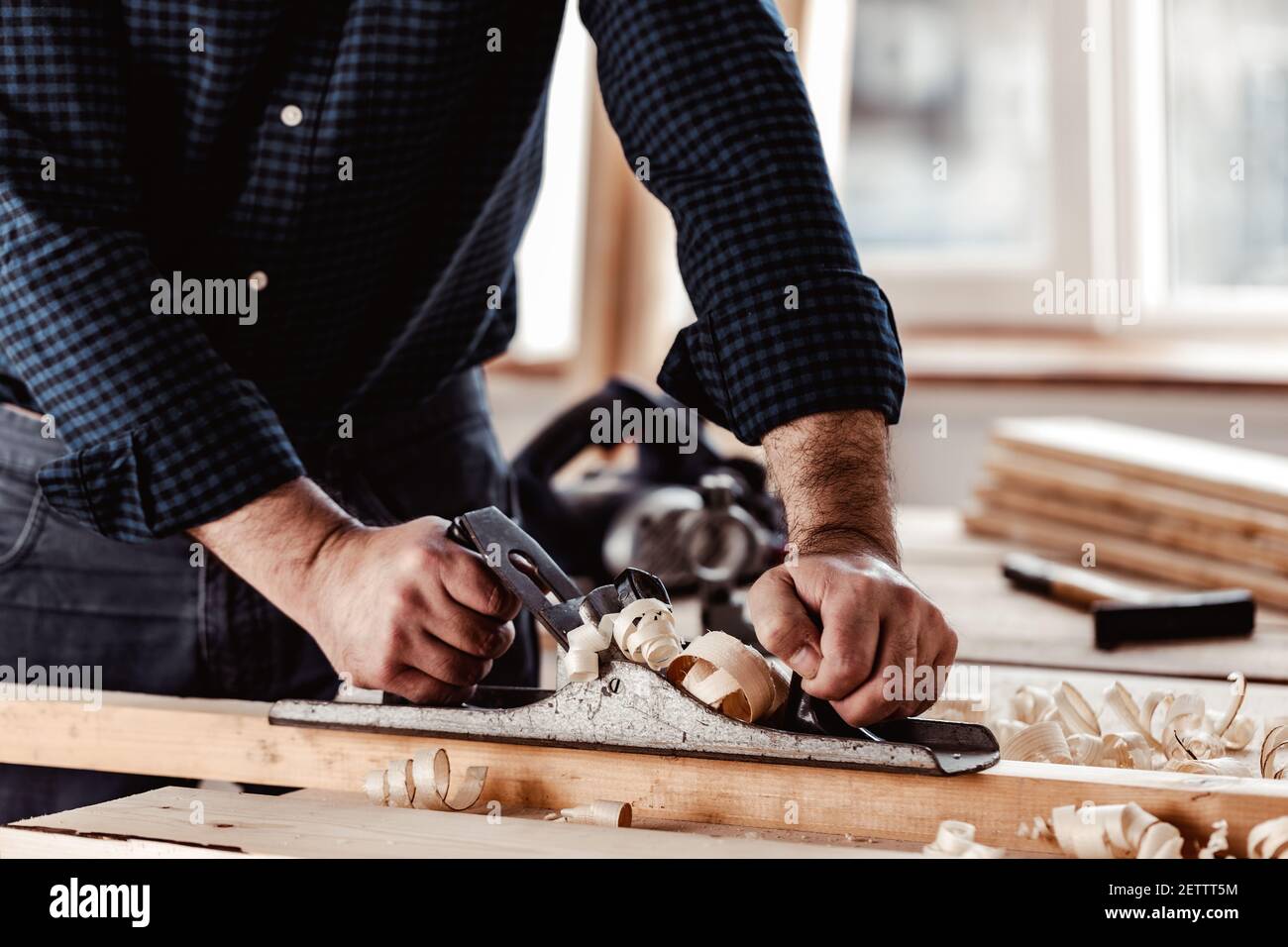 Les mains de Carpenter plantant une planche de bois avec une main plan Banque D'Images