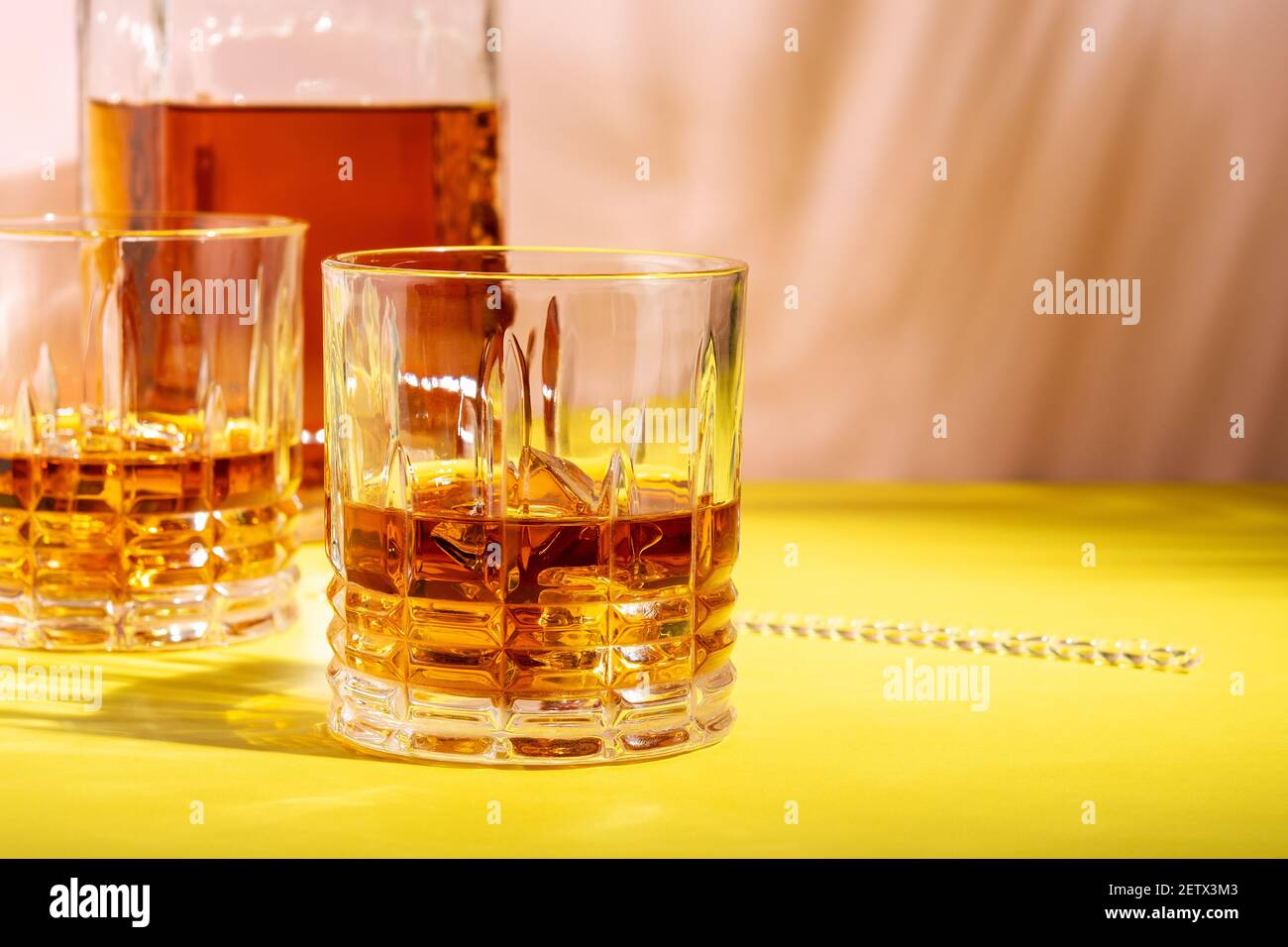 Le rhum ou l'Amaretto s'aigre avec de la glace dans un verre sur un fond lumineux. Concept de fête d'été. Banque D'Images