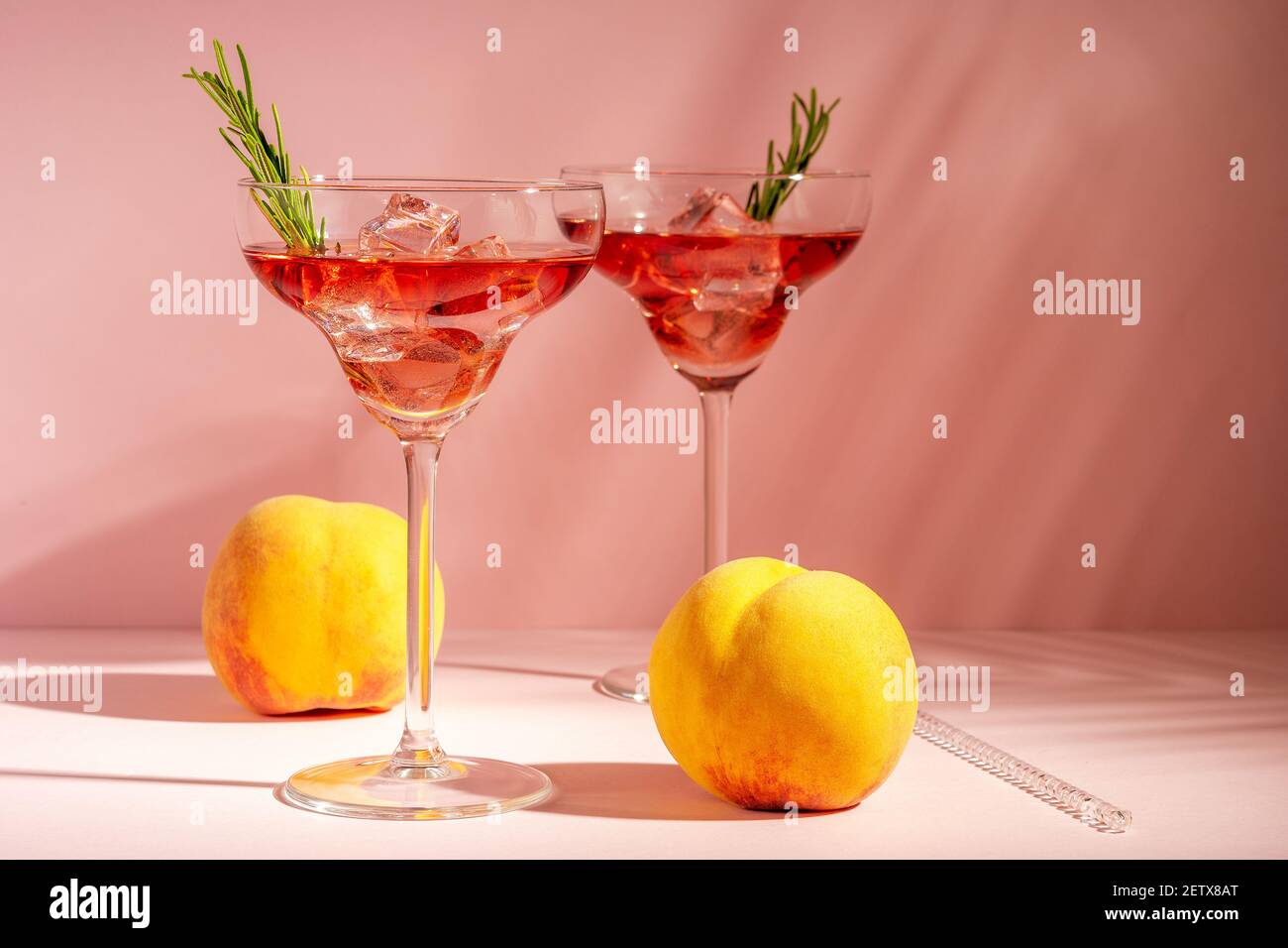 Cocktail rafraîchissant dans un verre avec pêche sur fond lumineux. Concept de fête d'été. Banque D'Images