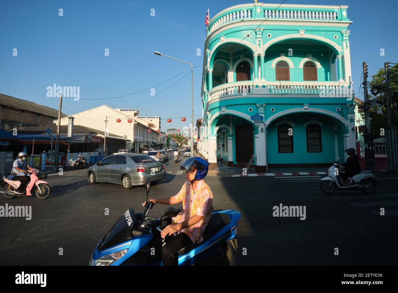 Motocyclistes passant devant un bâtiment sino-portugais à l'angle de Yaowarat Rd / Dibuk Rd dans la vieille ville (Chinatown) de Phuket Town, Thaïlande Banque D'Images