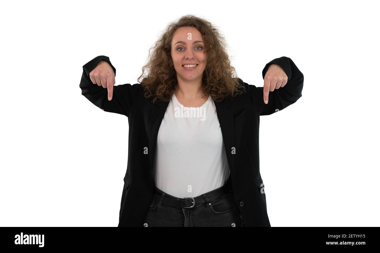 Femme en costume pointant vers le bas avec ses deux mains isolées sur fond blanc. La femme a des cheveux bouclés blonds. Banque D'Images