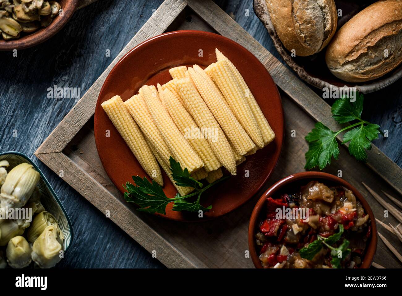 vue en grand angle d'une assiette avec un peu de maïs sucré sur une table à côté d'un bol avec un peu d'escalivada espagnol, fait avec différents légumes rôtis, un Banque D'Images