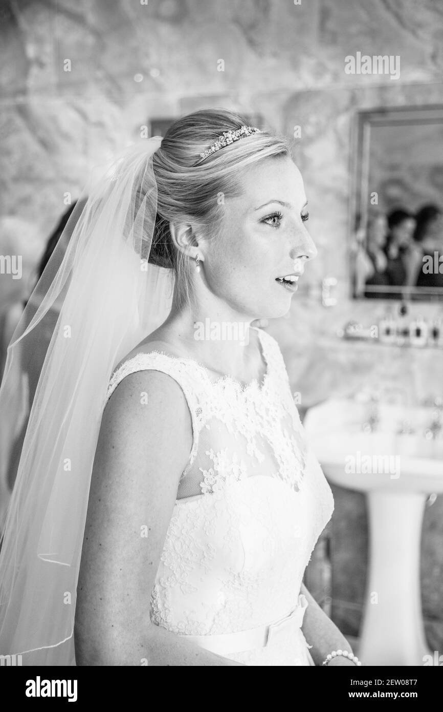 Mariée regardant dans le miroir, vous pouvez également voir ses réflexions de demoiselles d'honneur dans un miroir en arrière-plan. Banque D'Images