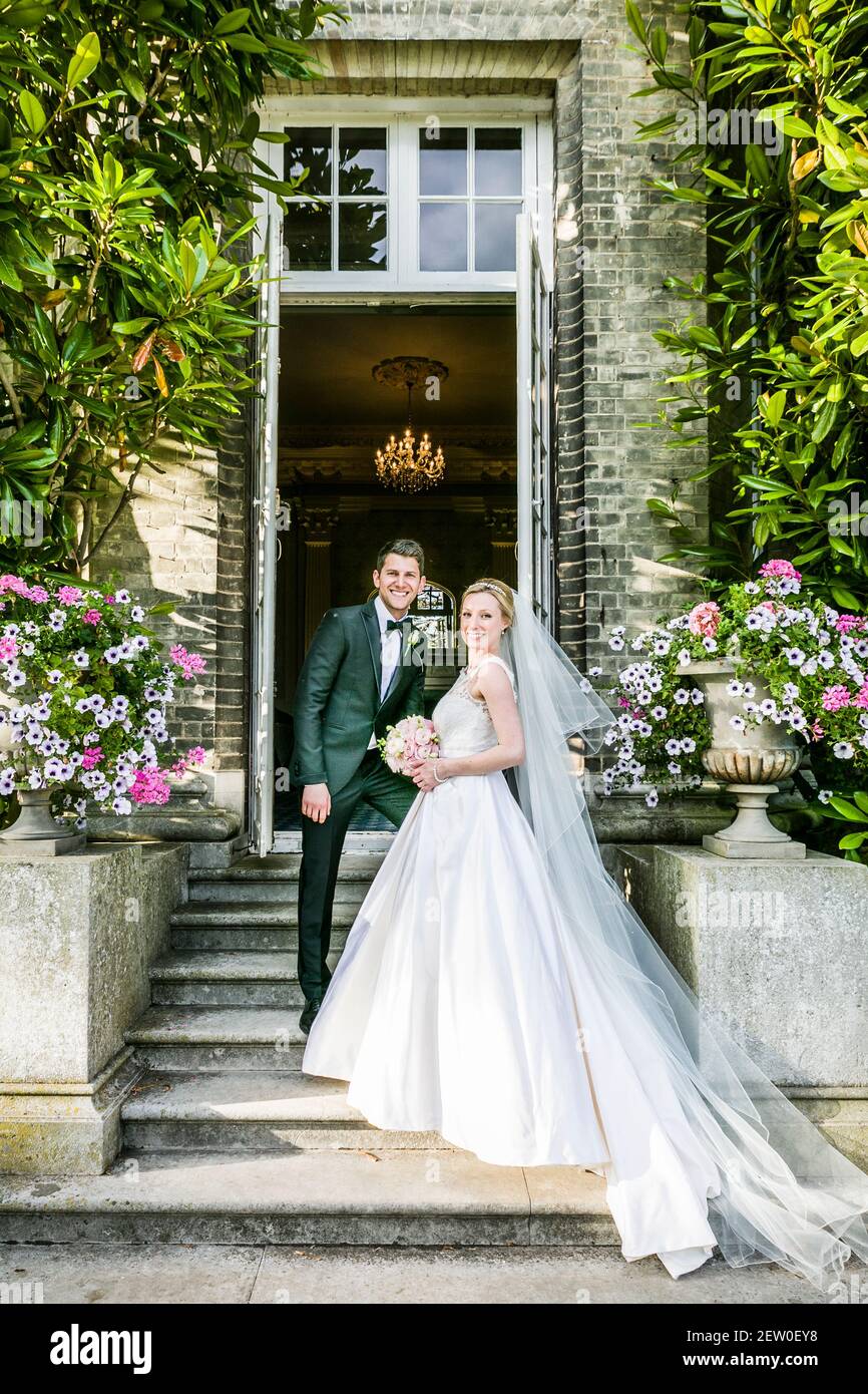 Mariée et mariée récemment-weds debout sur les marches de pierre de la  maison de maître qu'ils ont loué pour la journée Photo Stock - Alamy