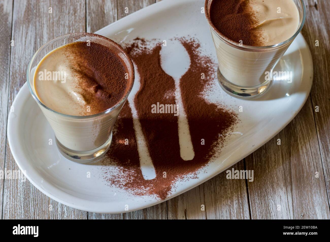 café ricotta, cuillère de dessert dans une tasse de verre servi dans une assiette blanche Banque D'Images