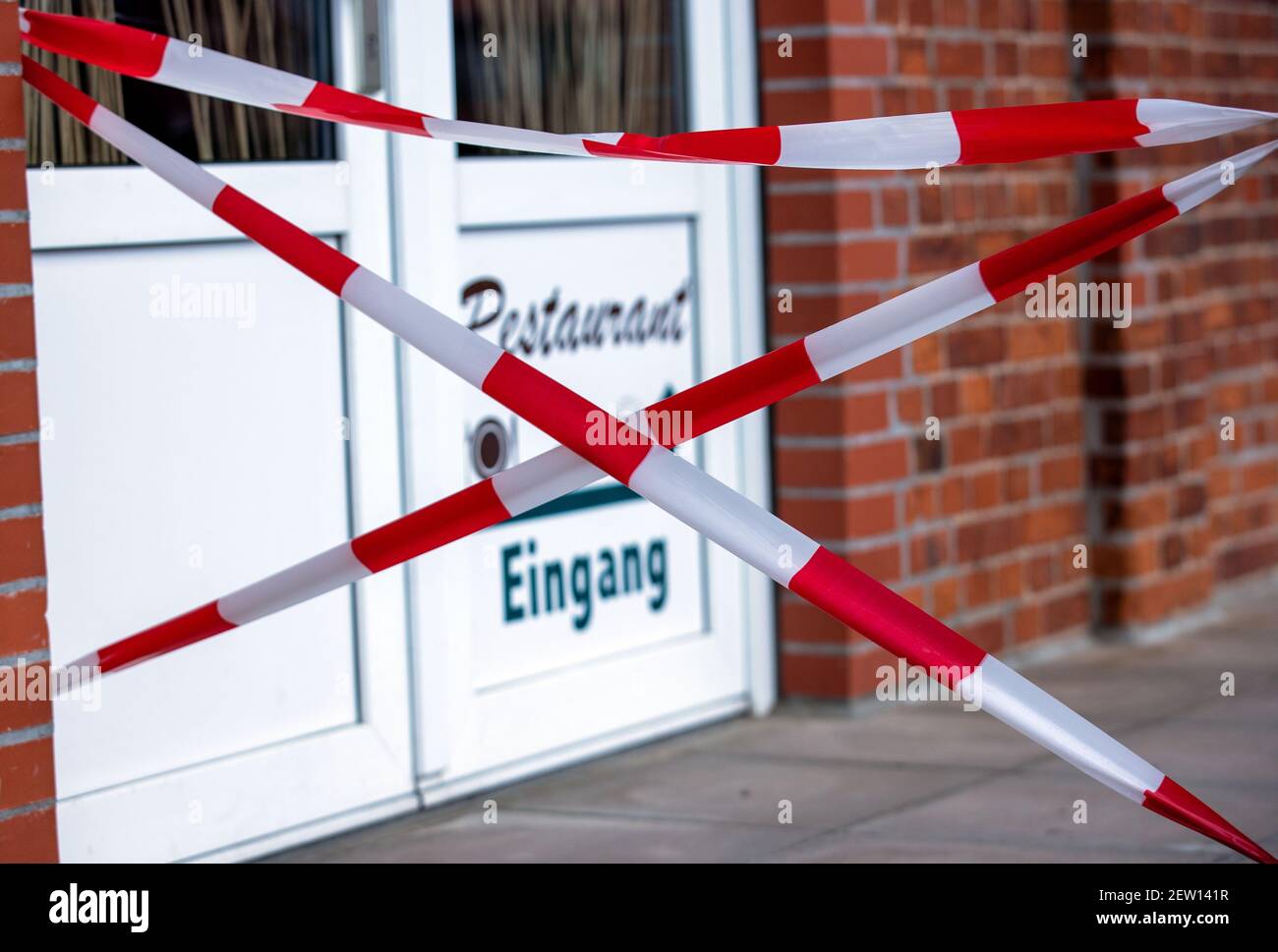 Boizenburg, Allemagne. 02 mars 2021. L'entrée d'un restaurant du port est barrée de ruban barrière rouge et blanc. En raison des mesures de protection de Corona, les restaurants et les cafés sont fermés depuis des mois. Credit: Jens Büttner/dpa-Zentralbild/dpa/Alay Live News Banque D'Images