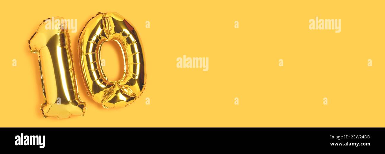 Bannière avec numéro 10 ballons dorés avec place pour votre conception. Concept de célébration de dix ans sur fond jaune. Banque D'Images