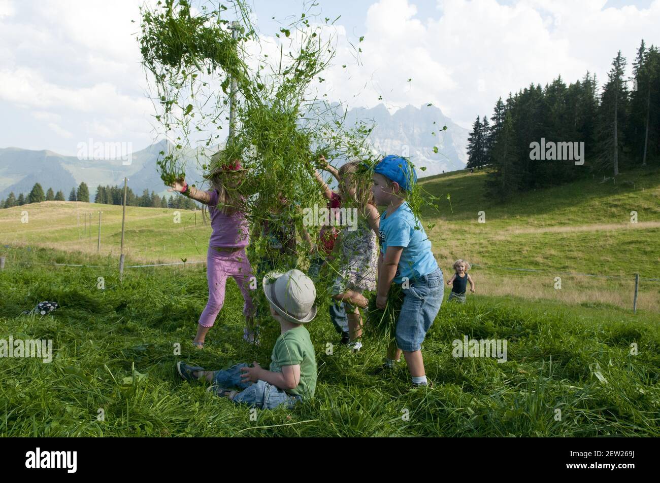 Suisse, canton du Valais, Morgins, enfants jouant dans l'herbe coupée Banque D'Images