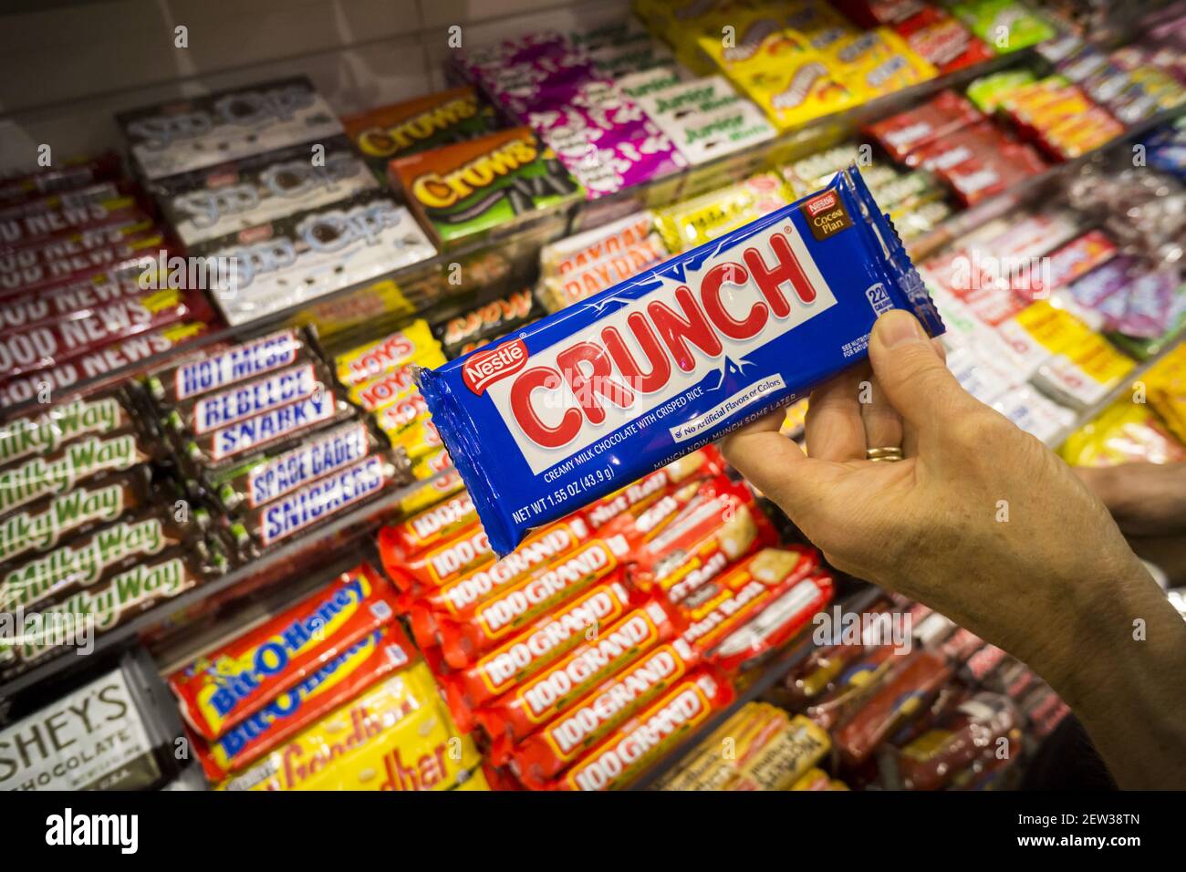 Un acheteur choisit une barre de chocolat Crunch de marque Nestlé dans un  magasin à New York le mardi 5 septembre 2017. Les principaux confiseurs,  notamment Hershey, Mars, Mondelez et Leaf Brands,
