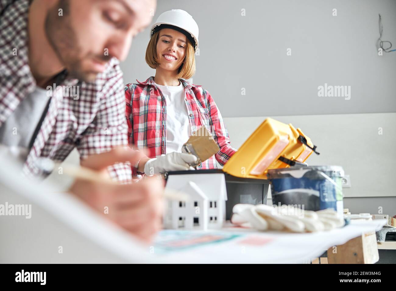 Une femme regardant un dessinateur s'est penchée sur un dessin technique Banque D'Images