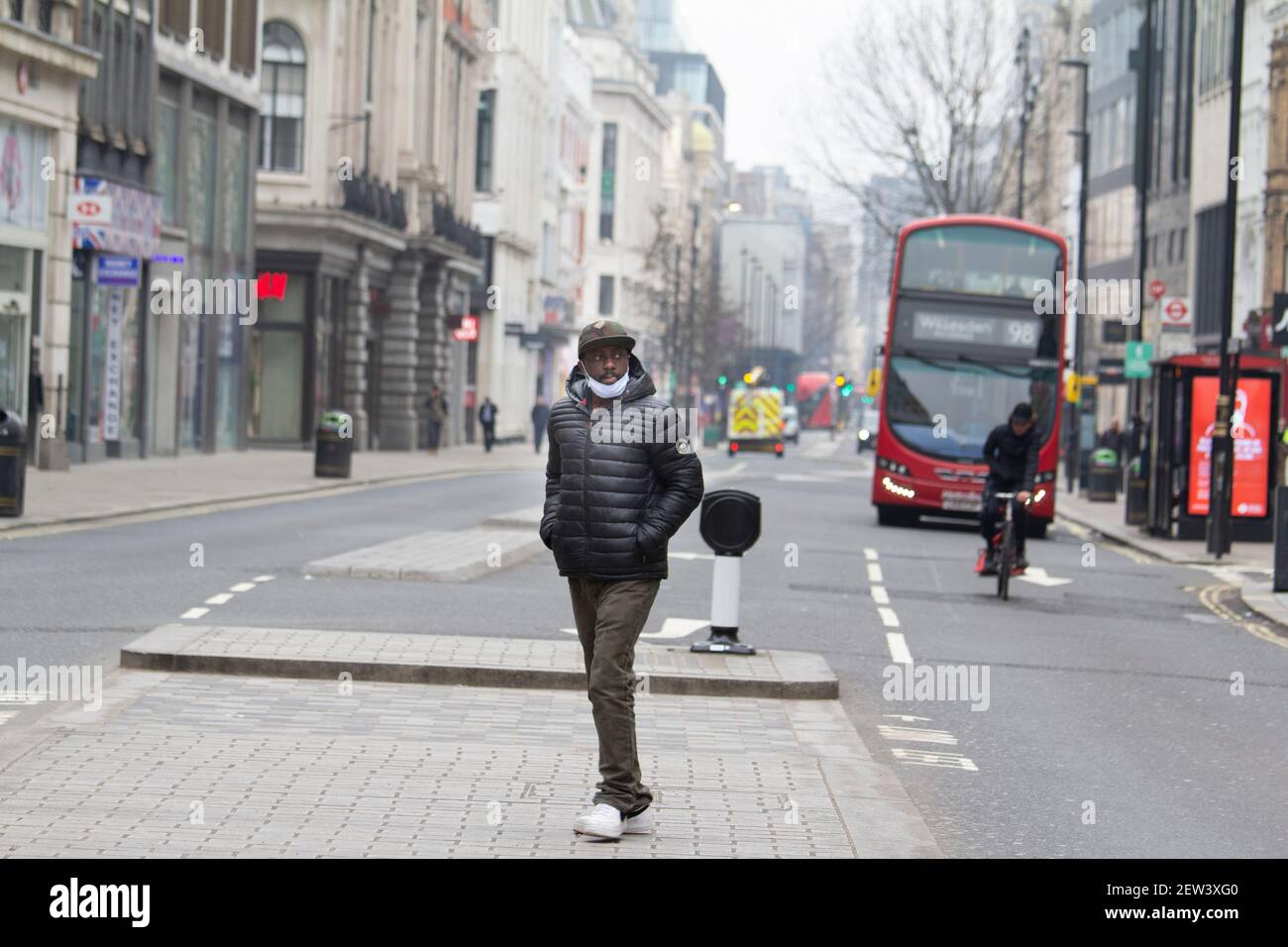 Oxford Street London, pendant le confinement pandémique du coronavirus Covid-19, Man traverse une rue exceptionnellement calme d'Oxford, portant des masques epi Banque D'Images