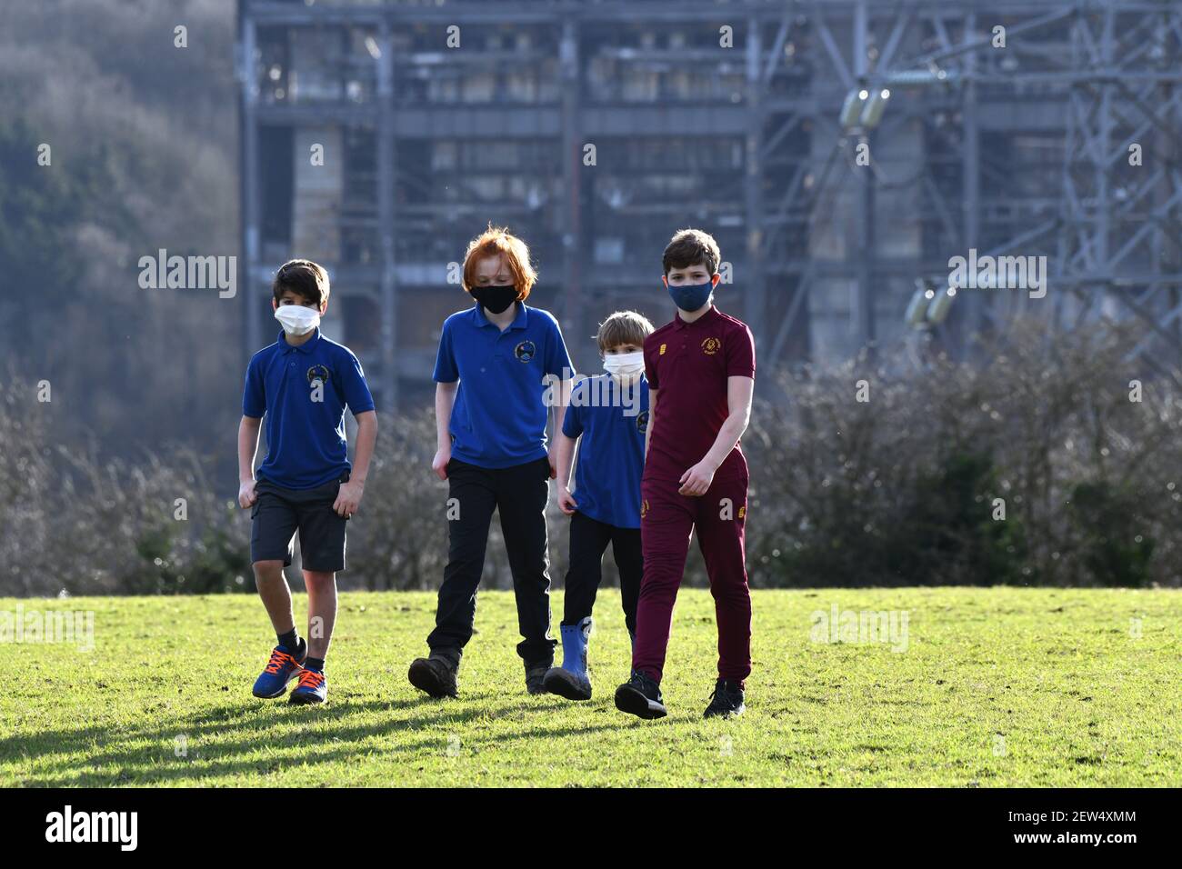 Enfants d'écoles marchant près d'un site industriel portant des masques pendant une pandémie Grande-Bretagne, Royaume-Uni, 2021 PHOTO PAR DAVID BAGNALL Banque D'Images