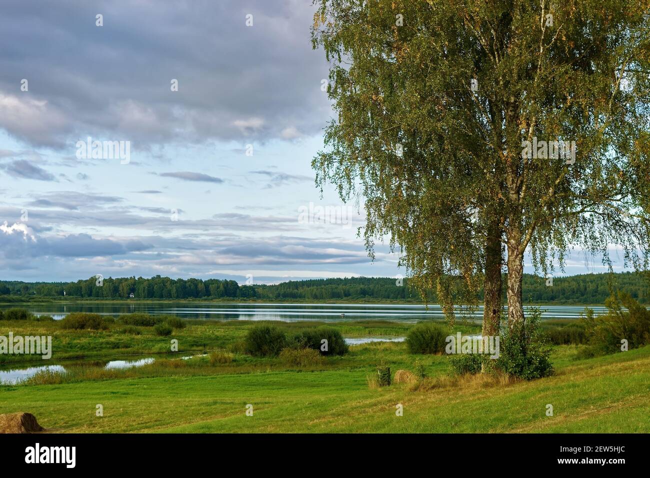 Paysage d'automne avec un lac, une rivière et un pré mown dans la région de Pskov. Banque D'Images