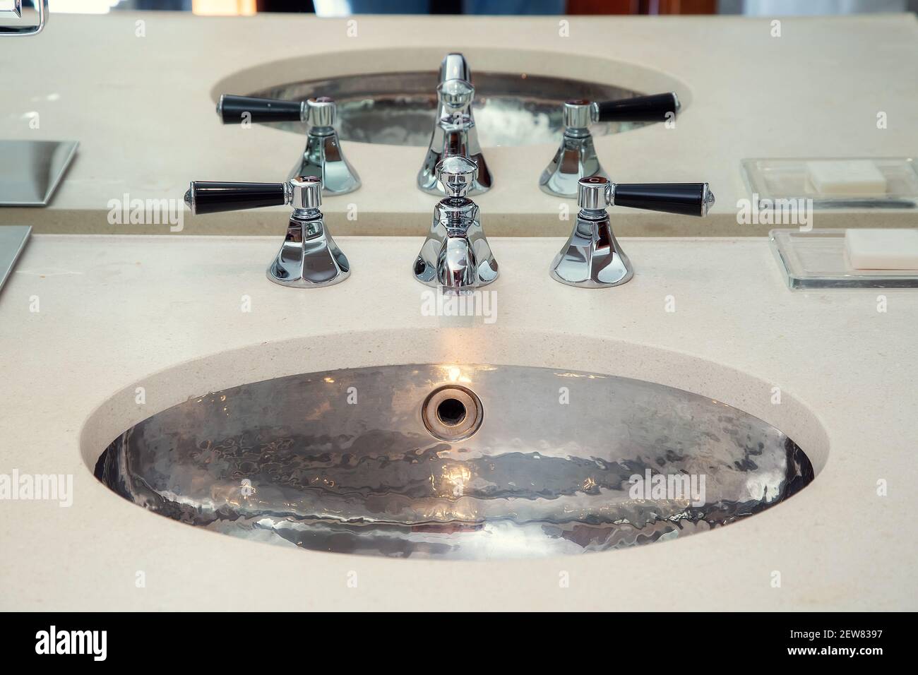 Lavabo en métal chromé avec mélangeurs dans la salle de bains Banque D'Images