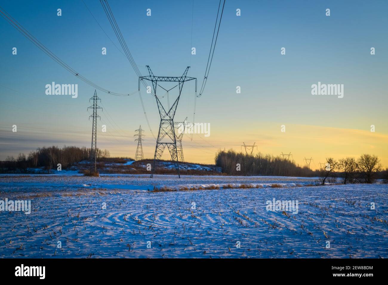 Tours de transmission d'électricité haute tension par câbles aériens en hiver Banque D'Images