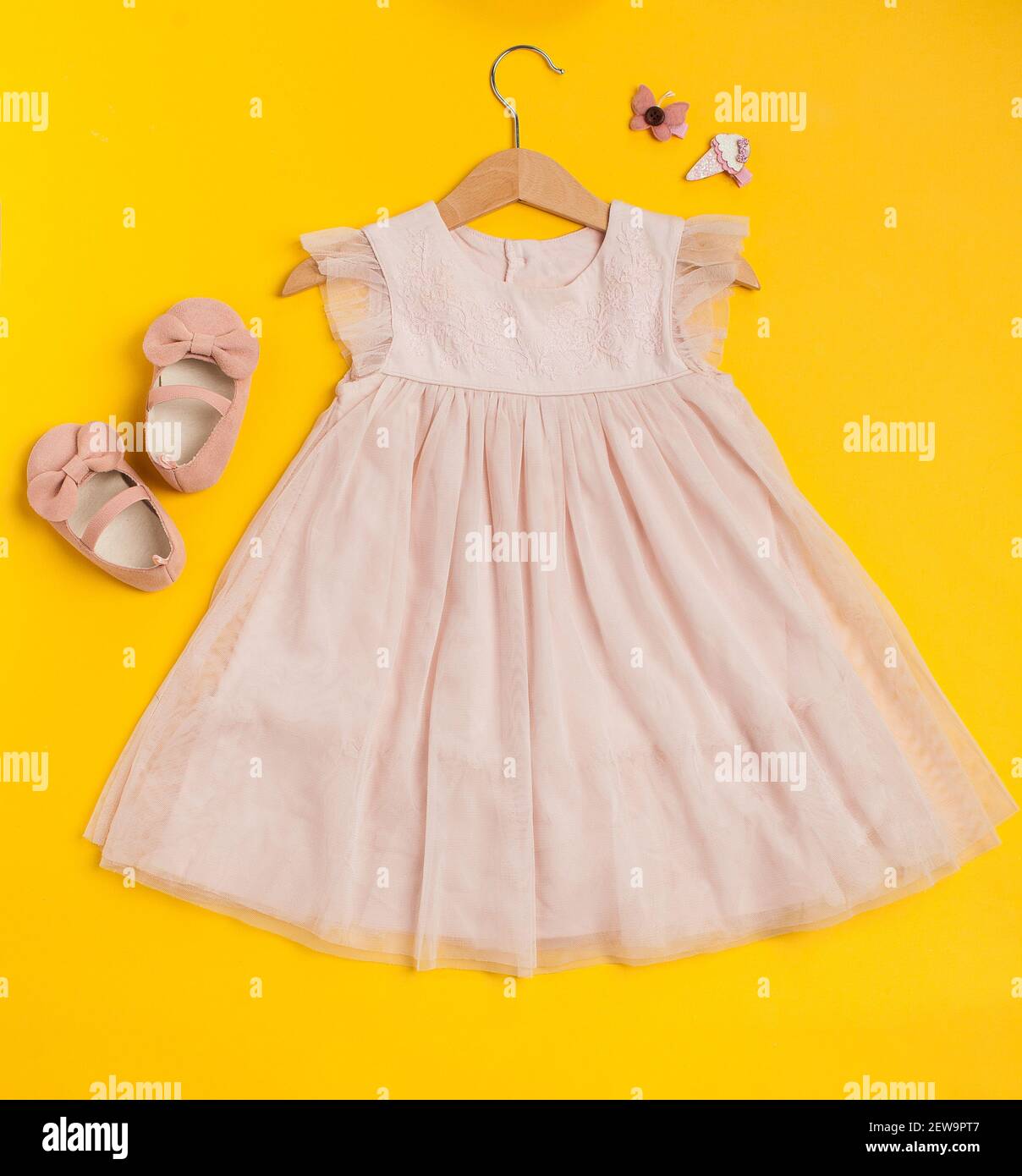 Tenue de fête pour enfants sur fond jaune.Jolie robe rose pour bébé avec  chaussures et épingles à cheveux Photo Stock - Alamy