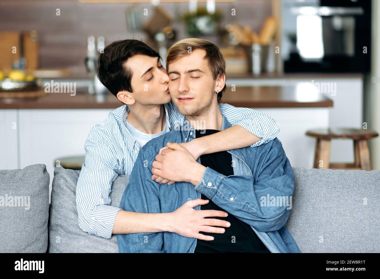 Les Homosexuels Se Détendent Sur Le Canapé Un Couple Gay Aimant Assis à La Maison Enserrer 