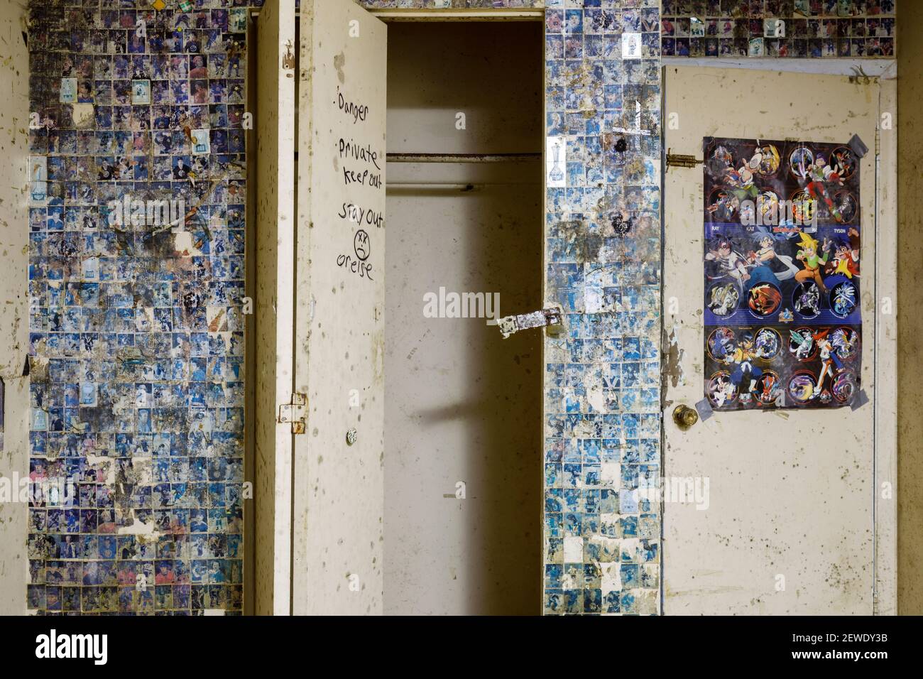 Un placard avec une serrure cassée et un mur recouvert d'autocollants à l'intérieur et la maison abandonnée. Ontario, Canada. Banque D'Images