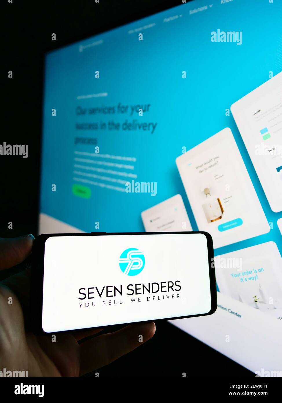 Personne tenant un smartphone avec le logo de la plate-forme de livraison allemande Seven Senders GmbH sur l'écran devant le site Web d'affaires. Mise au point sur l'affichage du téléphone. Banque D'Images