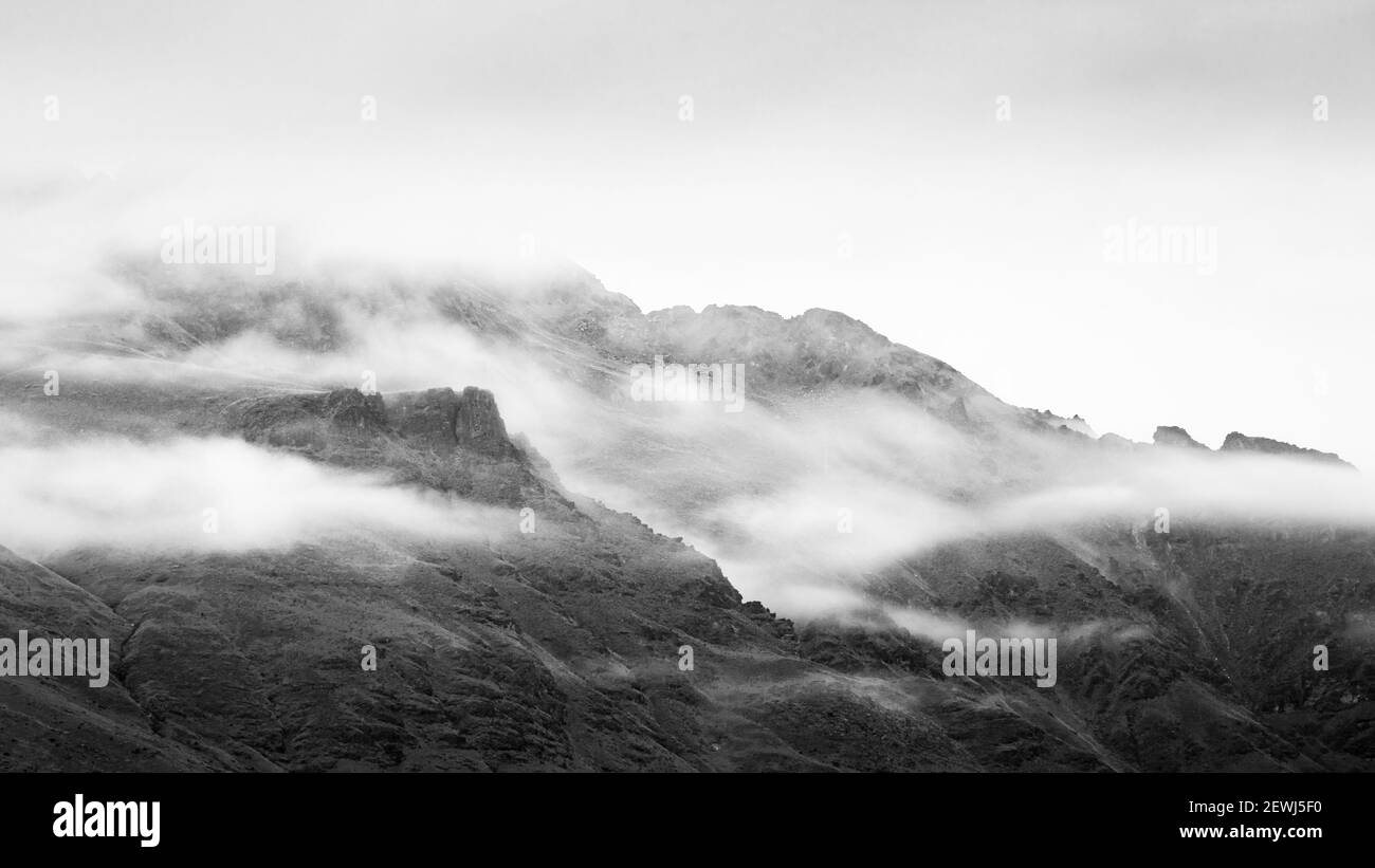 Image en noir et blanc des montagnes couvertes par le roulement brume Banque D'Images