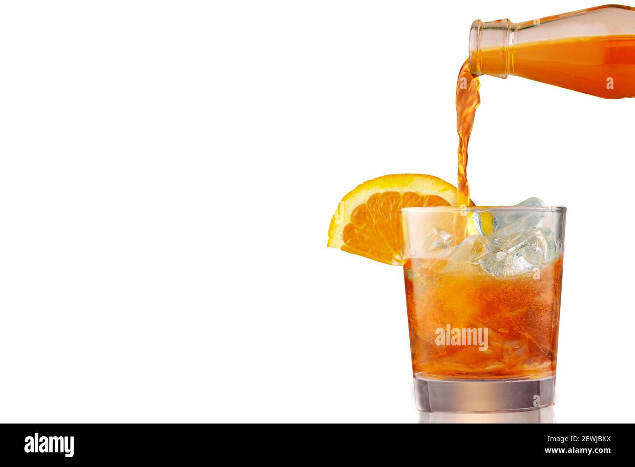 Verre de cocktail apéritif froid glacé Spritz décoré de tranches d'orange. Apéritif, faire de la queue de cocon, verser le liquide dans le verre plein de glace, isolé Banque D'Images