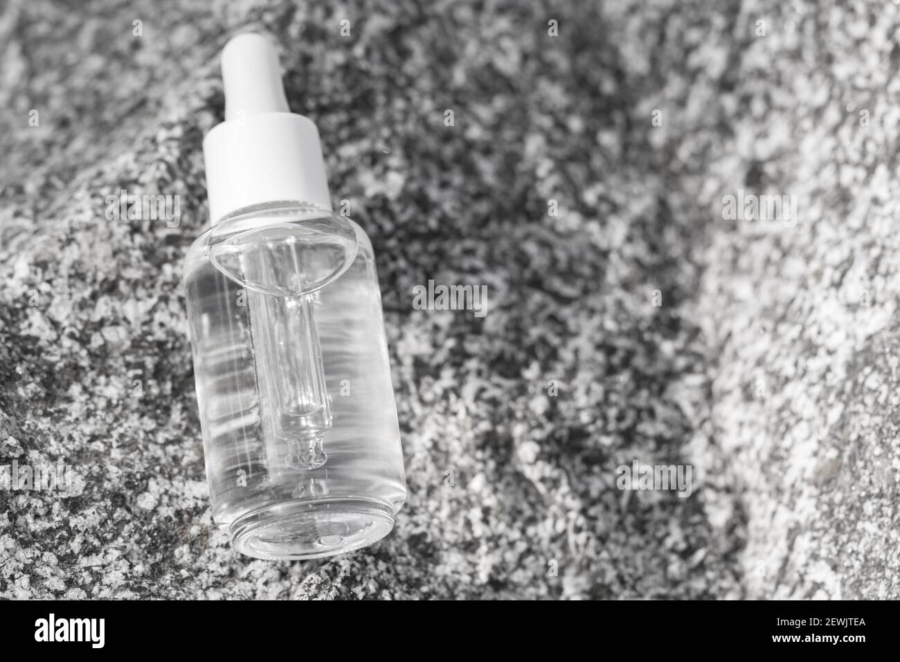 Flacon transparent en verre de sérum avec pipette sur la surface en pierre. Concept cosmétique naturel bio spa. Banque D'Images